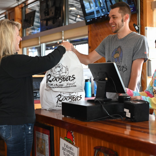 Roosters Employee giving food to customer