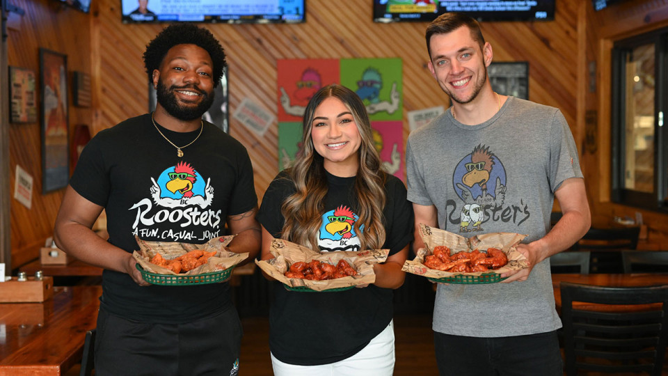 Roosters Employees holding wings